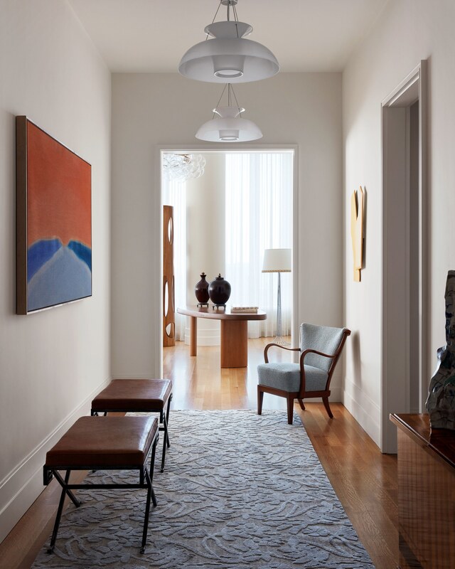 In the entrance gallery of a high-rise apartment in Manhattan, designer David Scott displays an eclectic mix of vintage and contemporary pieces: leather benches by Jean-Michel Frank, a curvy chair from Hostler Burrows and a vintage sideboard, adorned with a sculpture by Dutch ceramicist Babs Haenen. A silk runner from Doris Leslie Blau and a warm Susan Vecsey painting add texture and color. Three Yrjö Harsia Taifuuni pendants hang above.